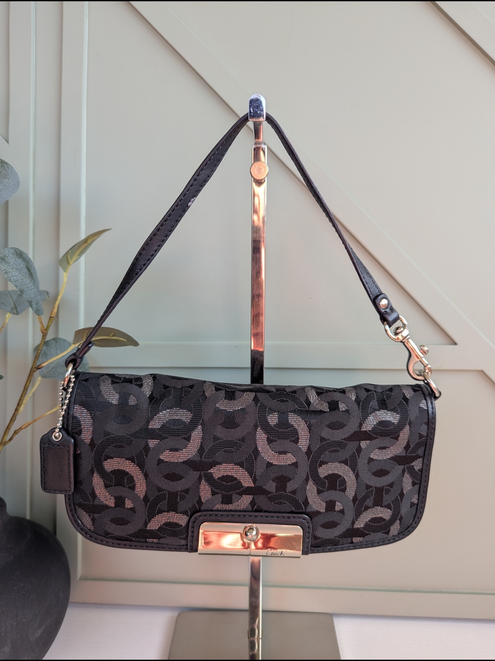 Coach Kristen wristlet featuring a black and silver interlocking C-pattern sate